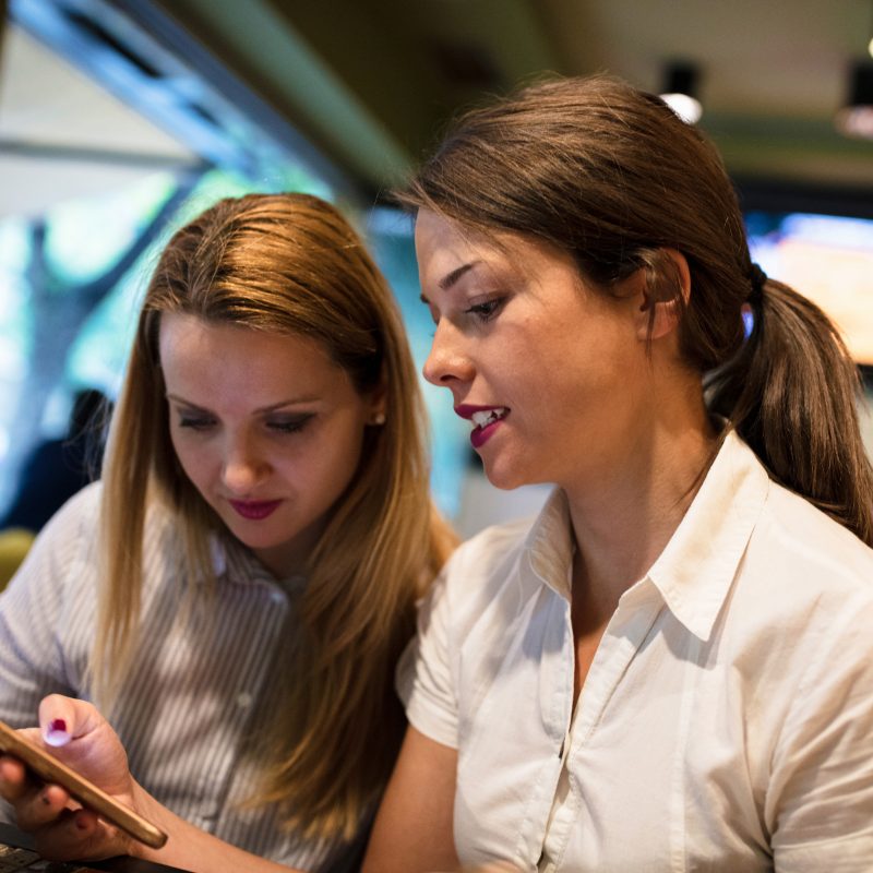 Two friends looking at a phone together