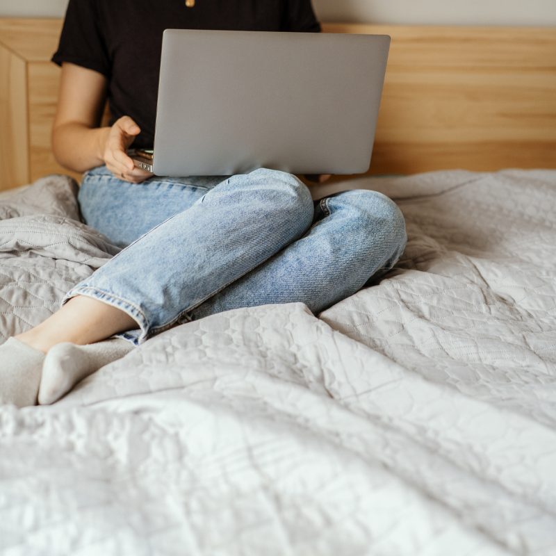 Laptop on a bed with a cosy throw
