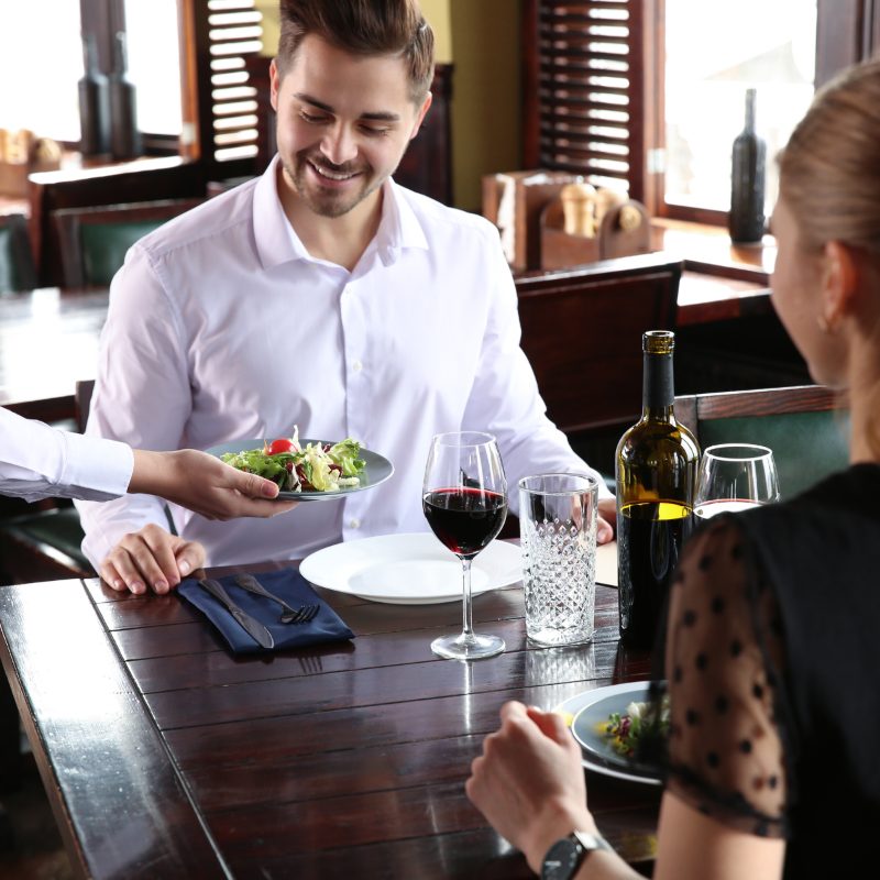 Waiter serving guests at dinner