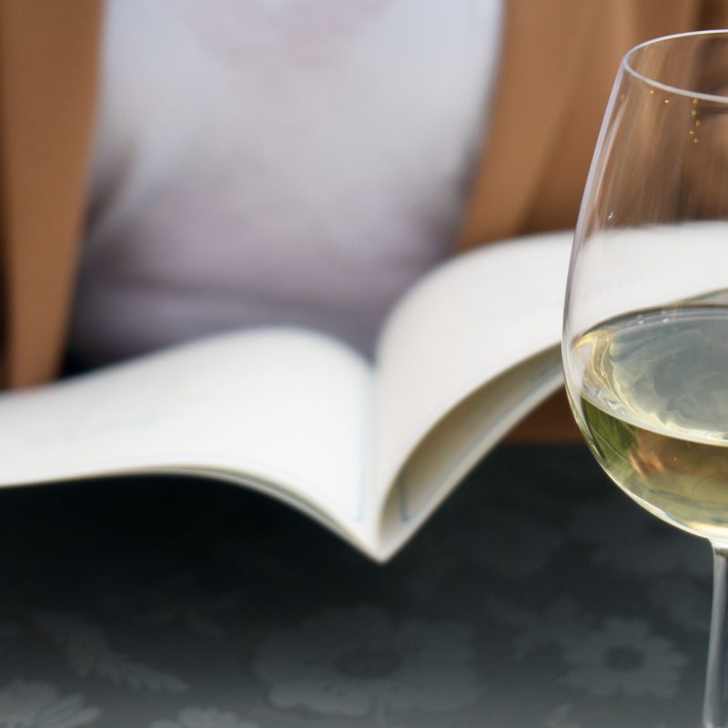 Guest reading the menu with a glass of wine